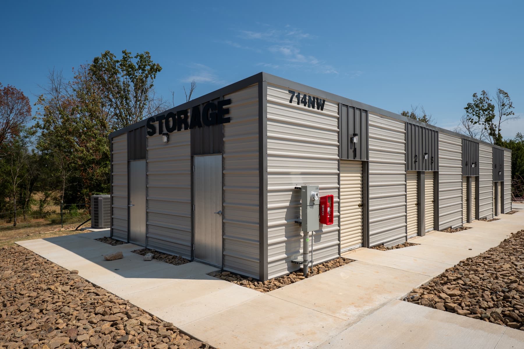 Front corner of the building with the STORAGE sign, 714 NW address, and a row of unit doors