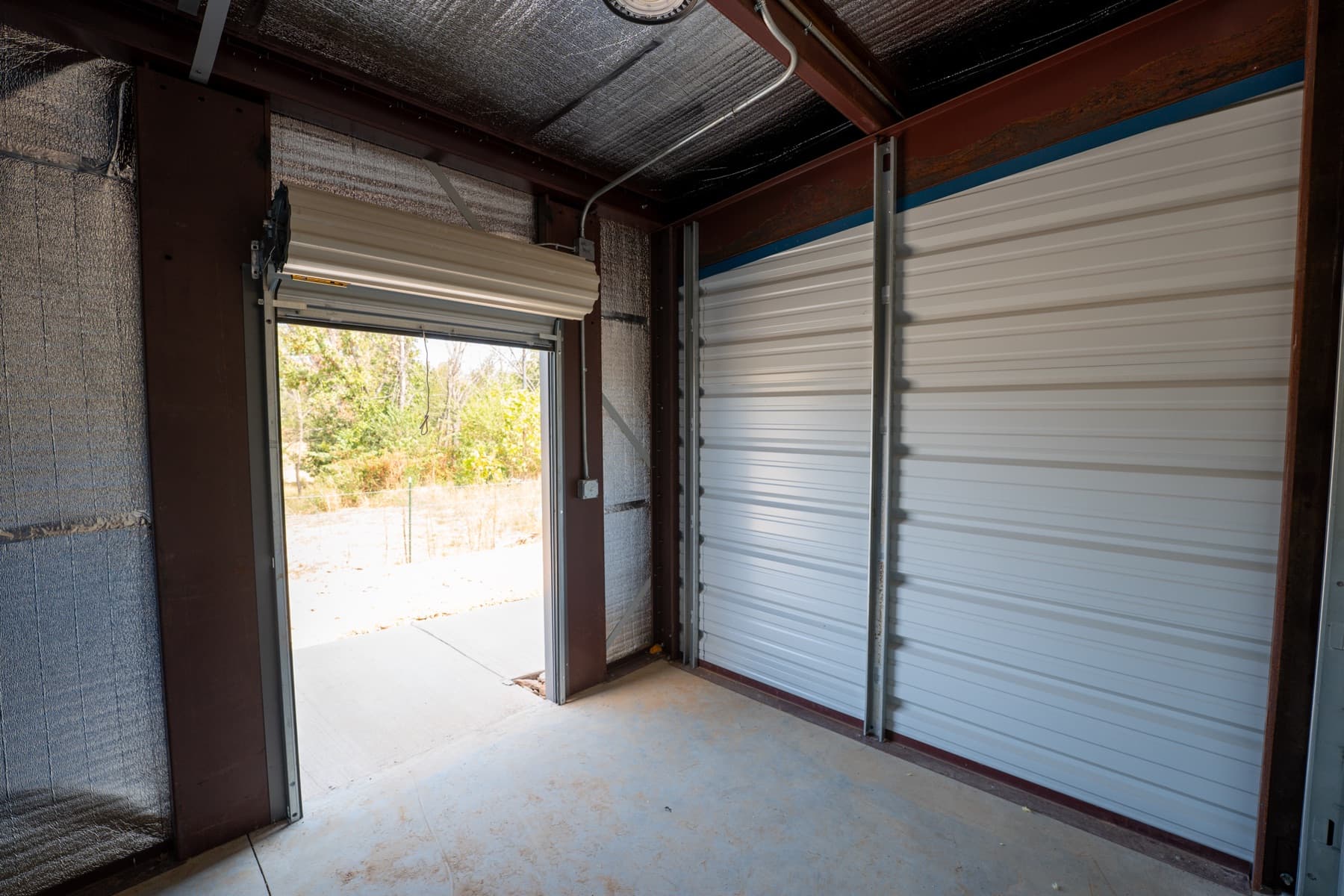 Inside a unit with the roll-up door open onto the front walk